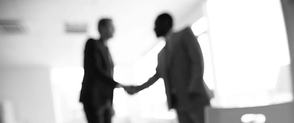 Stretta di mano tra due professionisti in ufficio
